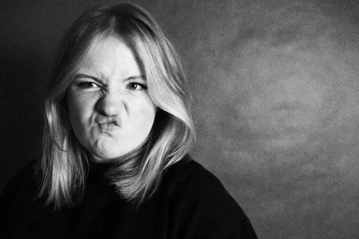 Black and white photo of a young woman with a comical sneer on her face.