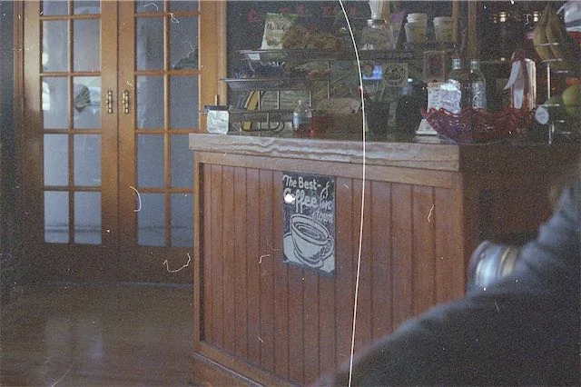 Hazy, dirty lens photo of coffee shop counter.