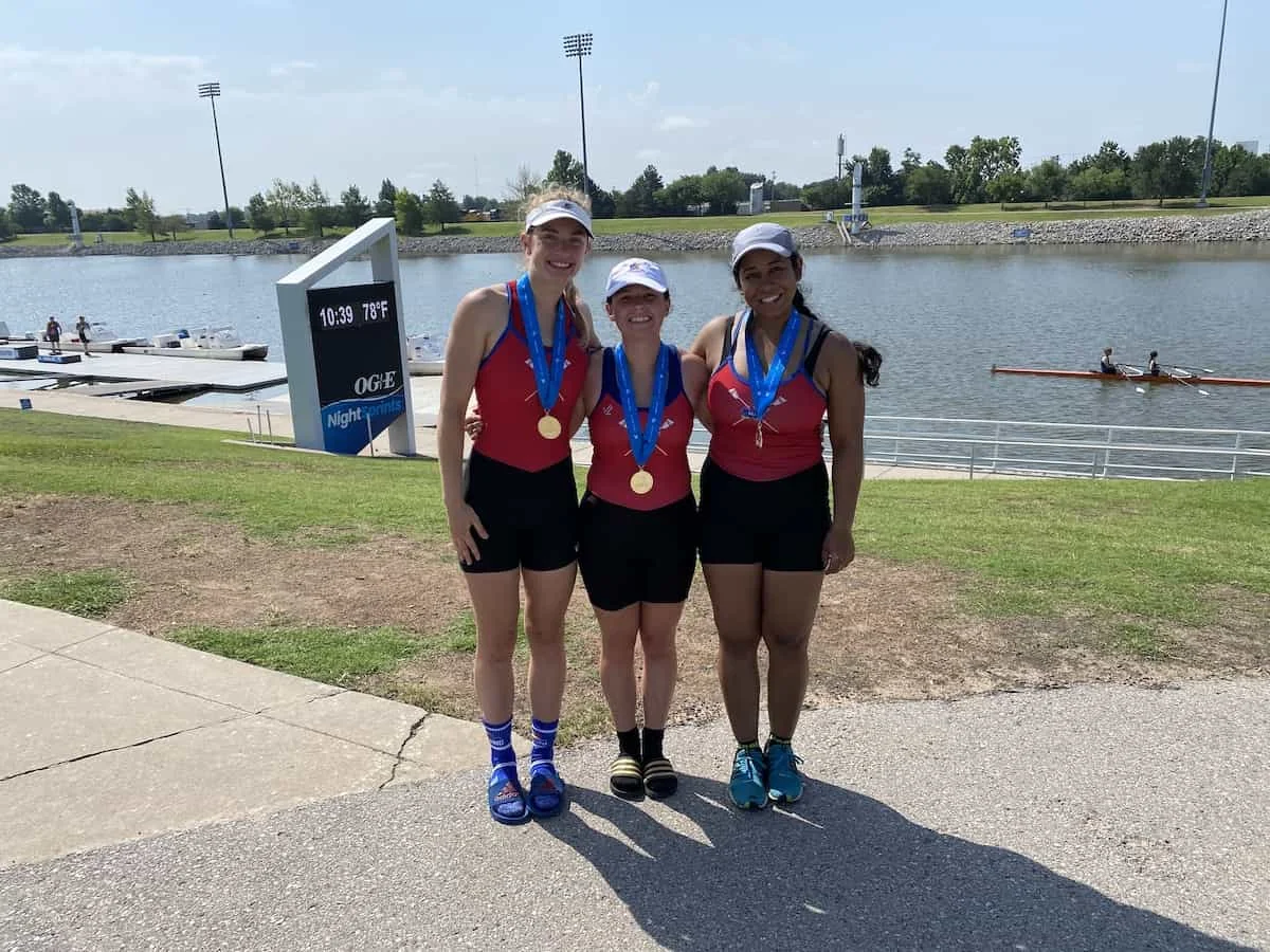 Three young female rowers wearing their medals.